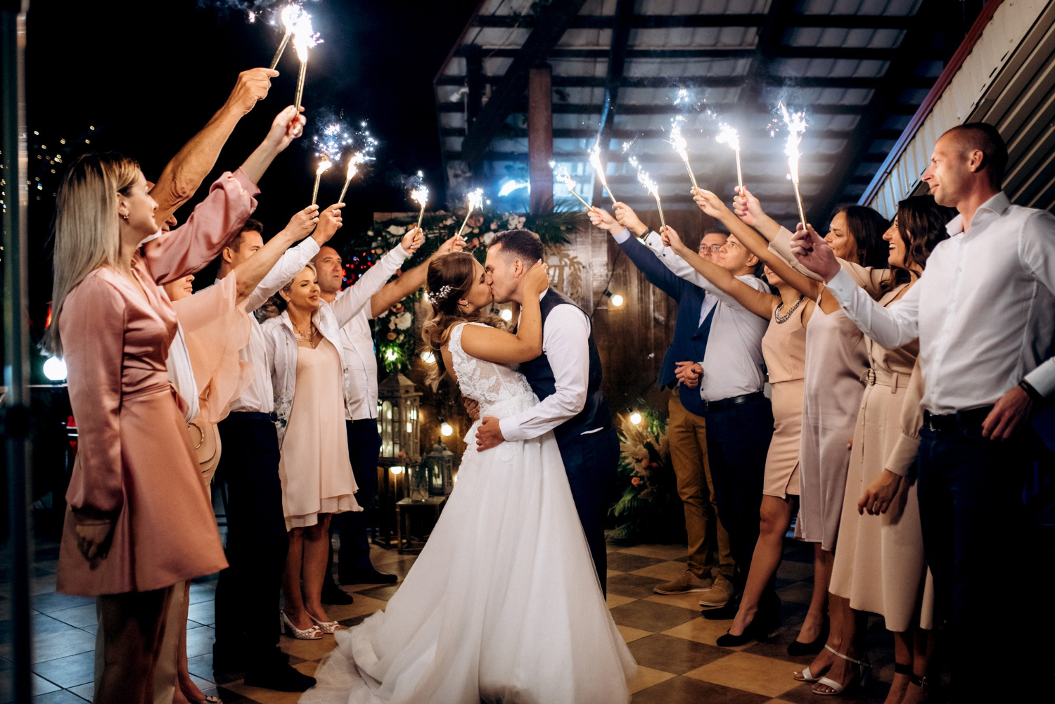 cold fire from cake candles and fireworks in the hands of people around the newlyweds